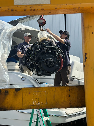 Marine technicians performing an engine repair on a boat at Chester Boat Basin in Chester, Connecticut.