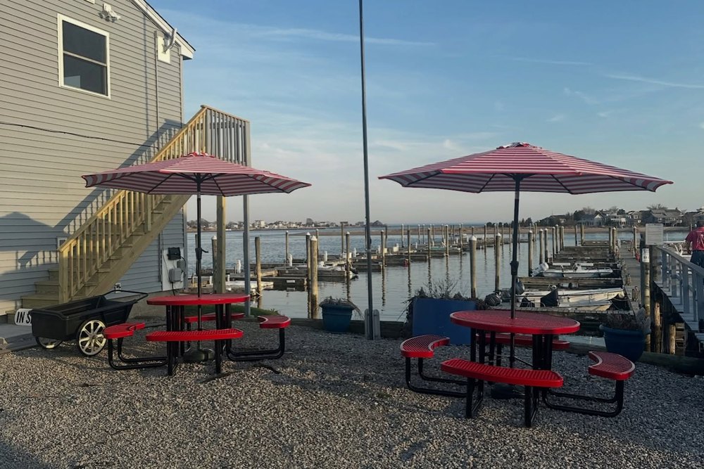 Picnic tables and umbrellas on the waterfront at Petzold's Port Clinton Marina