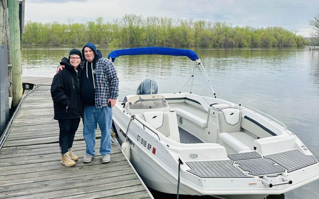Two boat owners standing on the dock beside their moored bowrider