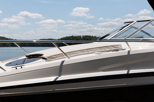 Sunlight reflecting off the polished hull, deck and windshield of a freshly detailed boat on calm water.
