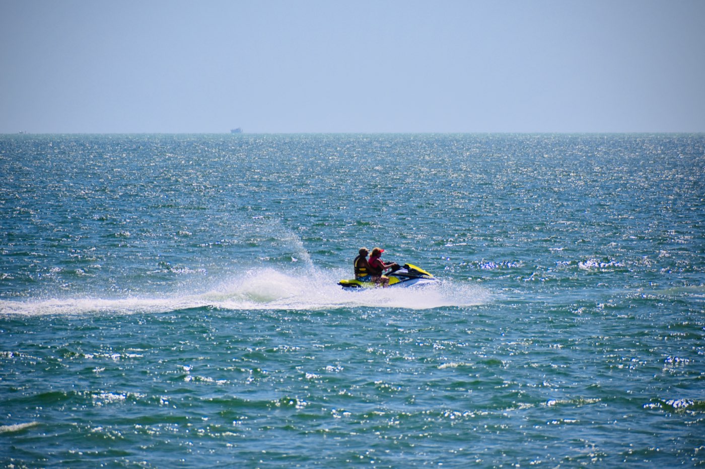 Two riders on a jet ski on open water