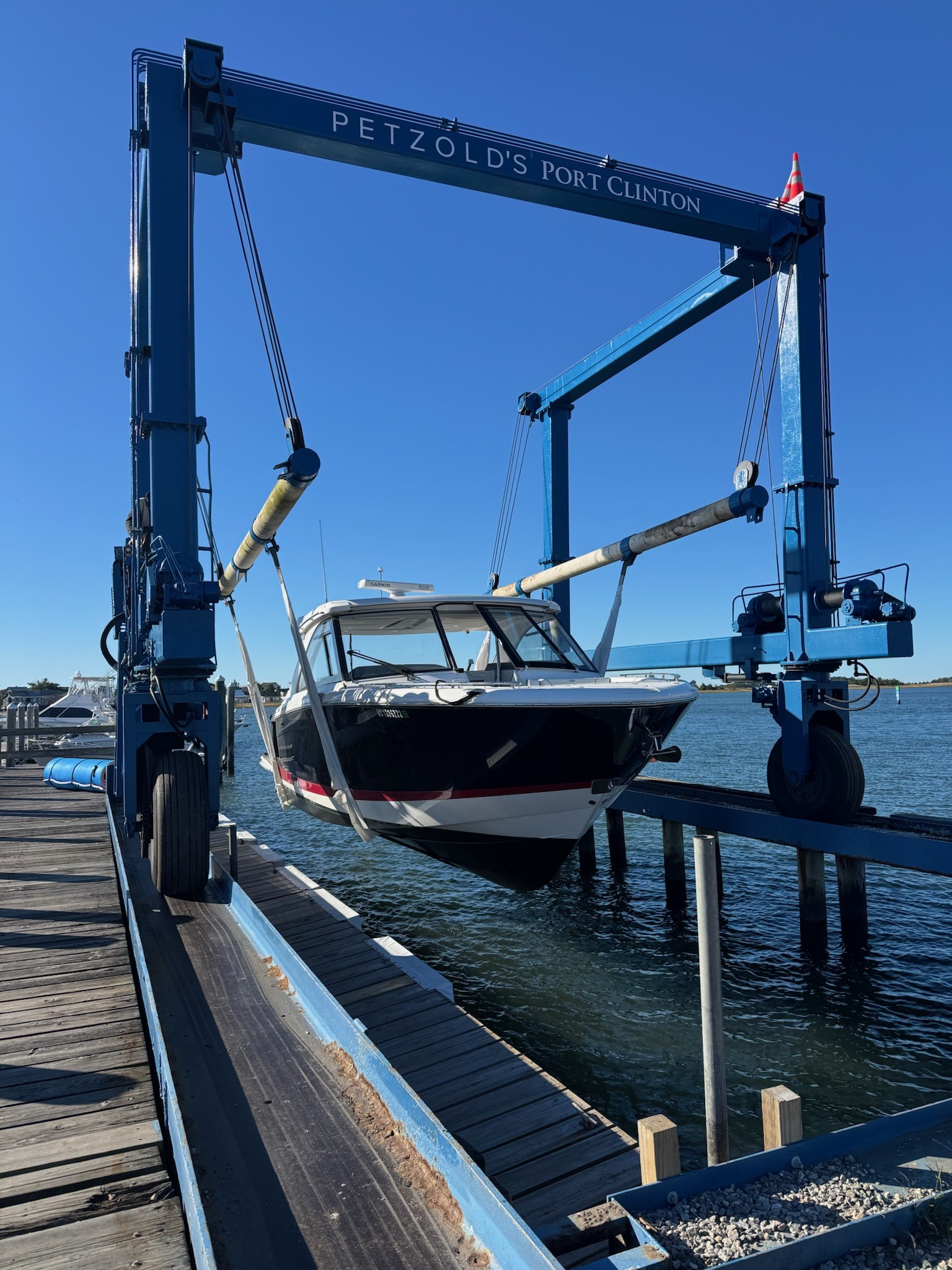 A technician servicing an outboard engine at the dock